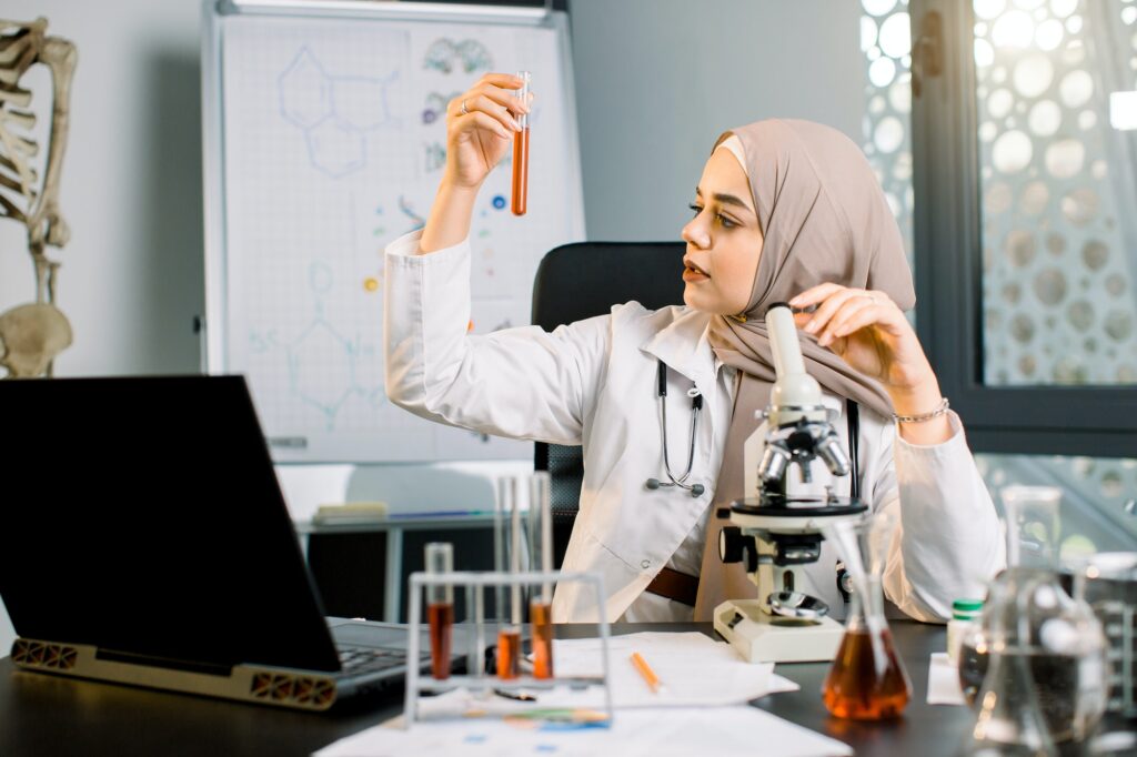 Portrait of muslim woman doctor chemist researcher studying test samples, analyzing red chemical
